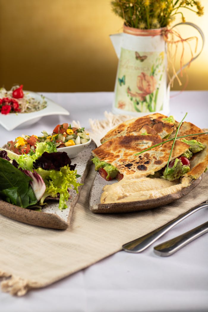 Delicious gourmet meal with salad and quesadilla, served on a rustic plate indoors.